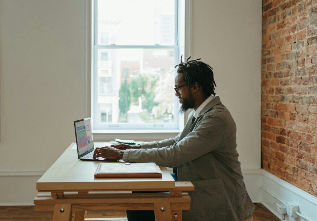 Freelancer trabalhando do lado de uma janela